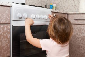 Child playing with stove knobs