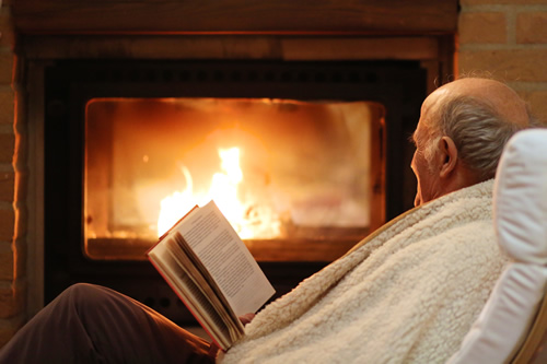 elderly people sitting by fireplace